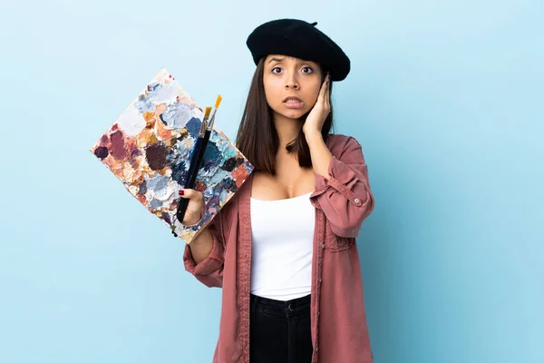 Jonge Kunstenaar Vrouw Met Een Palet Geïsoleerde Blauwe Achtergrond Gefrustreerd — Stockfoto