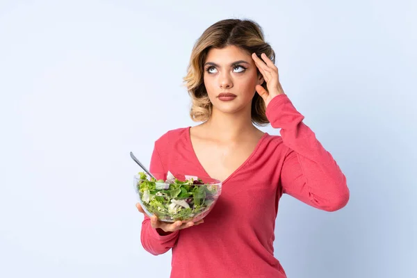 Mulher Adolescente Com Salada Isolada Fundo Azul Com Dúvidas Com — Fotografia de Stock