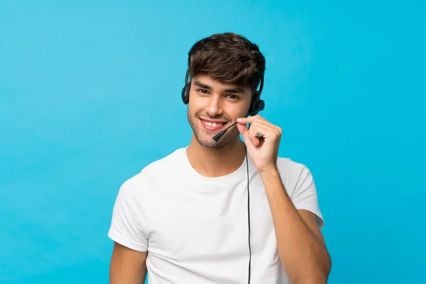 Jovem Homem Bonito Sobre Fundo Azul Isolado Trabalhando Com Fone — Fotografia de Stock