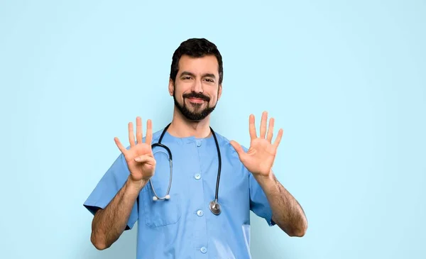 外科医生用手指在孤立的蓝色背景上数9个 — 图库照片