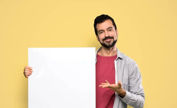 Bonito Homem Com Barba Segurando Cartaz Vazio Sobre Fundo Amarelo — Fotografia de Stock