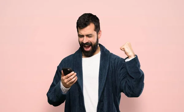 Hombre Con Barba Pijama Con Teléfono Posición Victoria Sobre Fondo —  Fotos de Stock