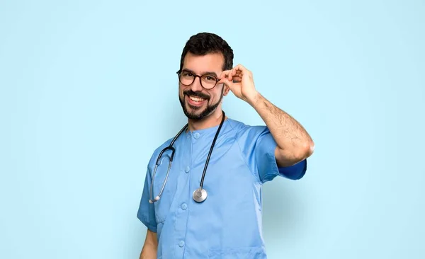 Cirujano Médico Hombre Con Gafas Sorprendido Sobre Fondo Azul Aislado —  Fotos de Stock