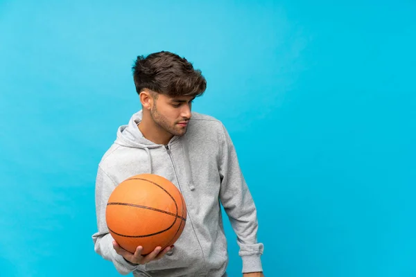 Pemuda Tampan Atas Latar Belakang Biru Terisolasi Dengan Bola Basket — Stok Foto