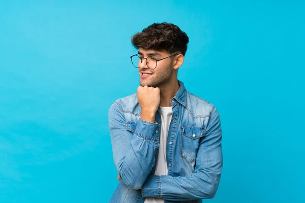 Jonge Knappe Man Geïsoleerde Blauwe Achtergrond Met Bril — Stockfoto