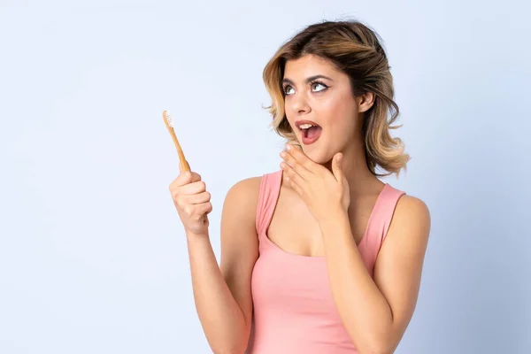 Menina Adolescente Escovando Dentes Isolados Fundo Azul Com Surpresa Expressão — Fotografia de Stock