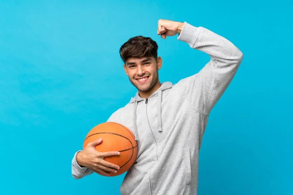 Joven Hombre Guapo Sobre Fondo Azul Aislado Con Pelota Baloncesto — Foto de Stock