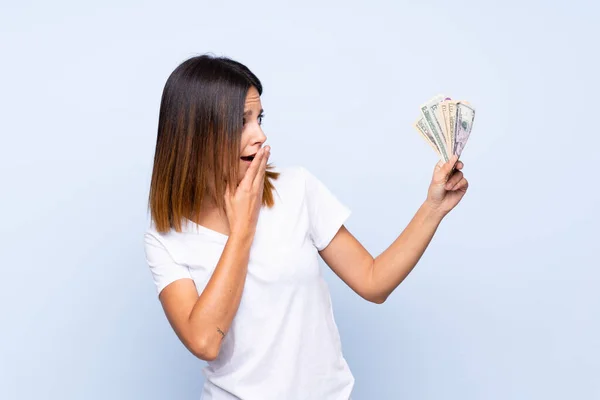Joven Mujer Sobre Aislado Azul Fondo Tomando Montón Dinero — Foto de Stock
