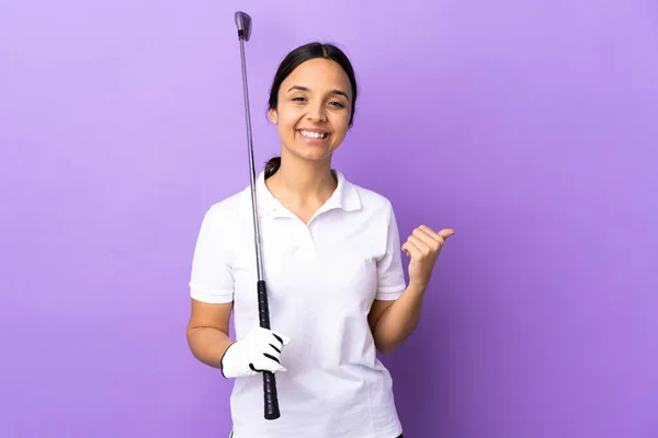 製品を提示するために側面を指して隔離されたカラフルな背景の上に若いゴルファーの女性 — ストック写真