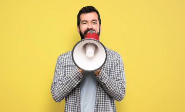 Handsome man with beard shouting through a megaphone