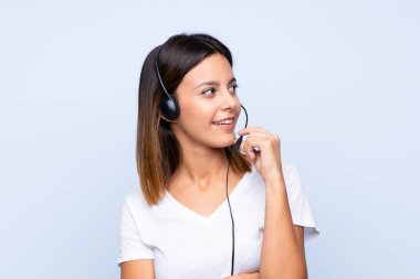 Tecrit edilmiş mavi geçmişi olan genç bir kadın kulaklıkla çalışıyor.