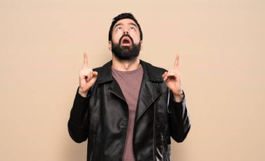 Sakallı yakışıklı adam şaşırdı ve işaret etti.