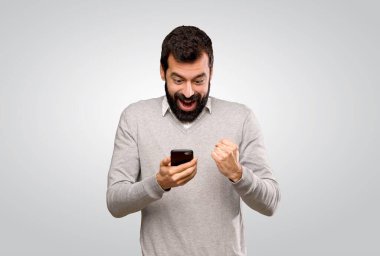 Yakışıklı adam şaşırdı ve gri arka planda bir mesaj gönderiyor.