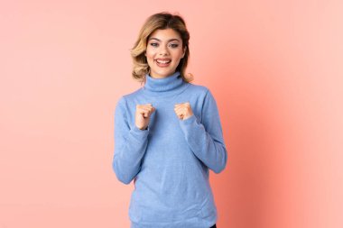 Pembe arka planda yalıtılmış genç bir Rus kadın.