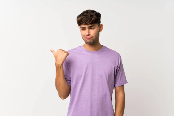 Jovem Homem Bonito Sobre Isolado Fundo Branco Infeliz Apontando Para — Fotografia de Stock