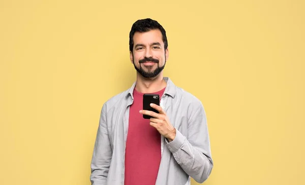 Hombre Guapo Con Barba Enviando Mensaje Con Móvil Sobre Fondo —  Fotos de Stock