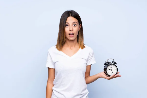 Mujer Joven Sobre Fondo Azul Aislado Sosteniendo Reloj Despertador Vintage —  Fotos de Stock