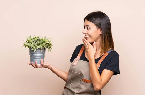 Giovane Donna Che Tiene Una Pianta Con Sorpresa Espressione Facciale — Foto Stock