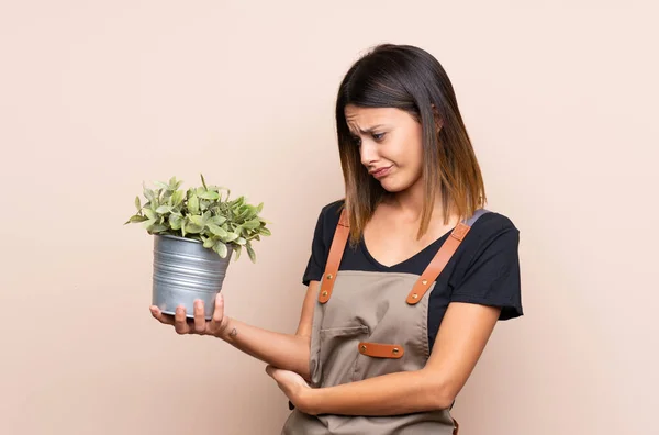 Jovem Segurando Uma Planta Com Expressão Triste — Fotografia de Stock