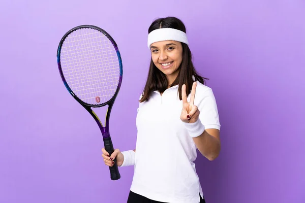 年轻女子网球选手在孤立的背景下微笑着并展示胜利的标志 — 图库照片