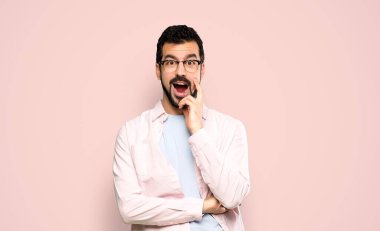 Sakallı, sakallı, şaşırmış ve şok olmuş bir yüz ifadesi olan yakışıklı bir adam.