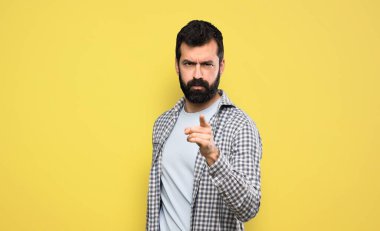 Handsome man with beard frustrated and pointing to the front