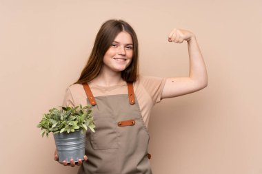 Ukraynalı genç bahçıvan kız elinde bir bitki tutuyor güçlü bir jest yapıyor