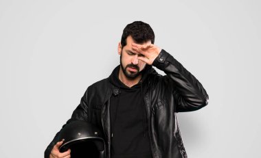 İzole edilmiş gri arka planda yorgun ve hasta suratlı bir motorcu.