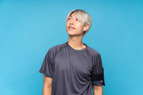 Junge Asiatische Sportler Über Isoliertem Blauem Hintergrund Der Lächelnd Nach — Stockfoto
