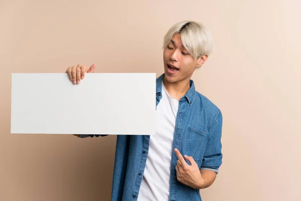 Νεαρός Ασιάτης Πάνω Απομονωμένο Φόντο Κρατώντας Μια Άδεια Λευκή Πινακίδα — Φωτογραφία Αρχείου