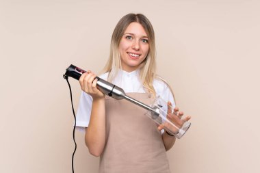 El blenderi kullanan genç sarışın kadın.