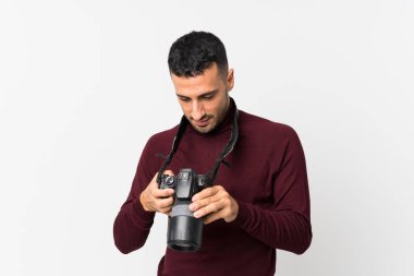 İzole edilmiş beyaz arka planda profesyonel kameralı genç bir adam.