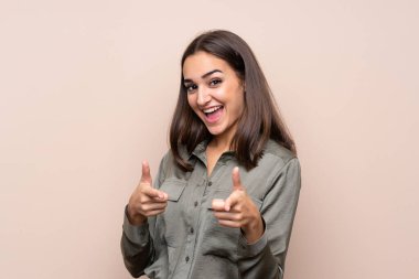 İzole edilmiş arka planda genç bir kız öne doğru bakıyor ve gülümsüyor.