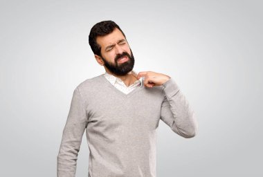 Gri arka planda yorgun ve hasta suratlı yakışıklı bir adam.