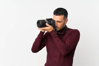 İzole edilmiş beyaz arka planda profesyonel kameralı genç bir adam.