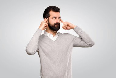 Gri arka planda kuşkuları olan yakışıklı bir adam.