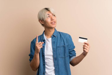 Soyutlanmış geçmişi olan genç bir Asyalı kredi kartı tutuyor.