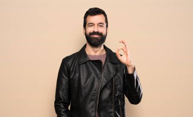 Sakallı yakışıklı adam parmaklarıyla işaret veriyor.