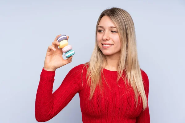 Jovem Mulher Loira Sobre Fundo Azul Isolado Segurando Macarons Franceses — Fotografia de Stock