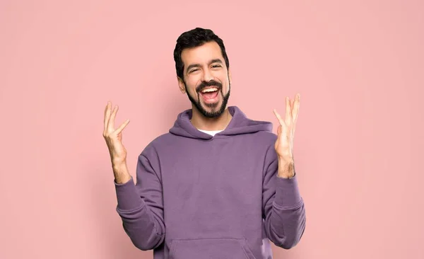 Knappe Man Met Sweatshirt Glimlachen Veel Geïsoleerde Roze Achtergrond — Stockfoto