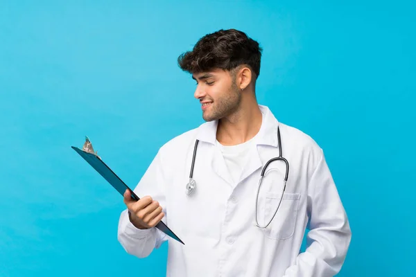 Jovem Homem Bonito Sobre Fundo Azul Isolado Com Vestido Médico — Fotografia de Stock