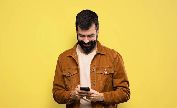 Knappe Man Met Baard Stuurt Een Bericht Met Mobiele Telefoon — Stockfoto