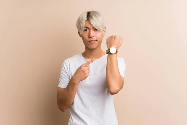 Joven Asiático Hombre Sobre Aislado Fondo Mostrando Mano Reloj Con — Foto de Stock