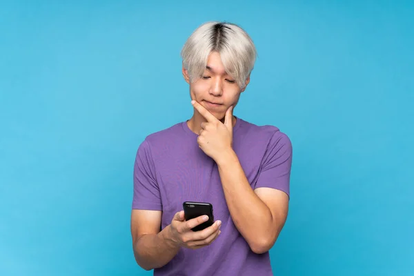 Fiatal Ázsiai Férfi Izolált Kék Háttér Gondolkodás Üzenet Küldése — Stock Fotó