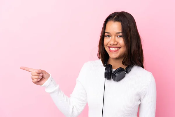 Mujer Joven Con Auriculares Sobre Una Pared Rosa Aislada Sorprendida —  Fotos de Stock