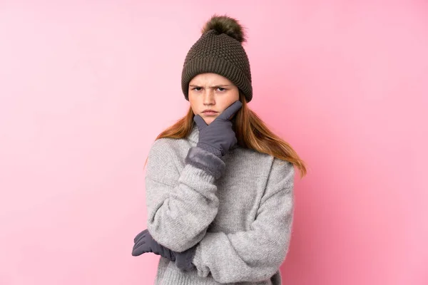 ウクライナのティーン女の子とともに冬の帽子以上隔離されたピンクの背景考え方 — ストック写真