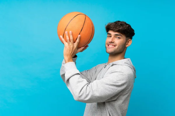 Joven Hombre Guapo Sobre Fondo Azul Aislado Con Pelota Baloncesto —  Fotos de Stock