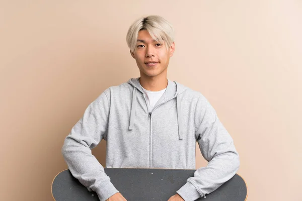 Junge Asiatische Mann Über Isolierten Hintergrund Mit Skate — Stockfoto