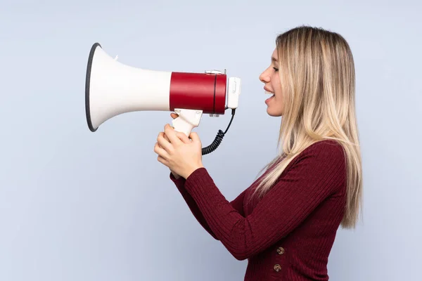 Jonge Blonde Vrouw Geïsoleerde Blauwe Achtergrond Schreeuwen Door Een Megafoon — Stockfoto