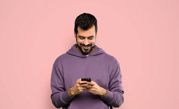 Hombre Guapo Con Sudadera Enviando Mensaje Con Móvil Sobre Fondo —  Fotos de Stock